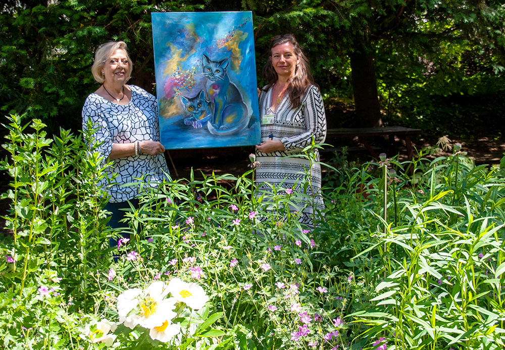 Die Künstlerin Dagmar Schnecke-Bend (links) hat das Bild "Glückskatzen" an die Kunsttherapeutin Michaela Killus übergeben. Foto: Rüdiger Beck